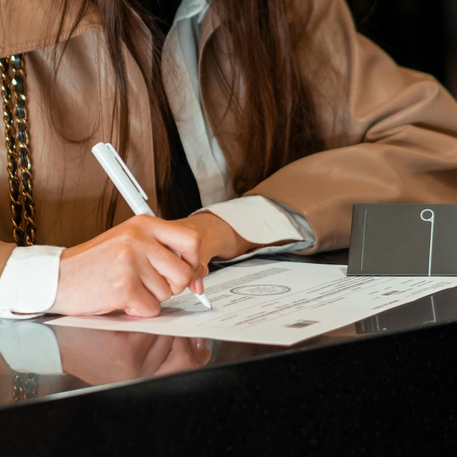 Madame qui signe un document